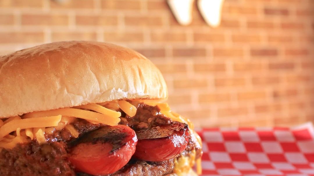 A Griff's grilled chili cheese dog burger on red checkered paper